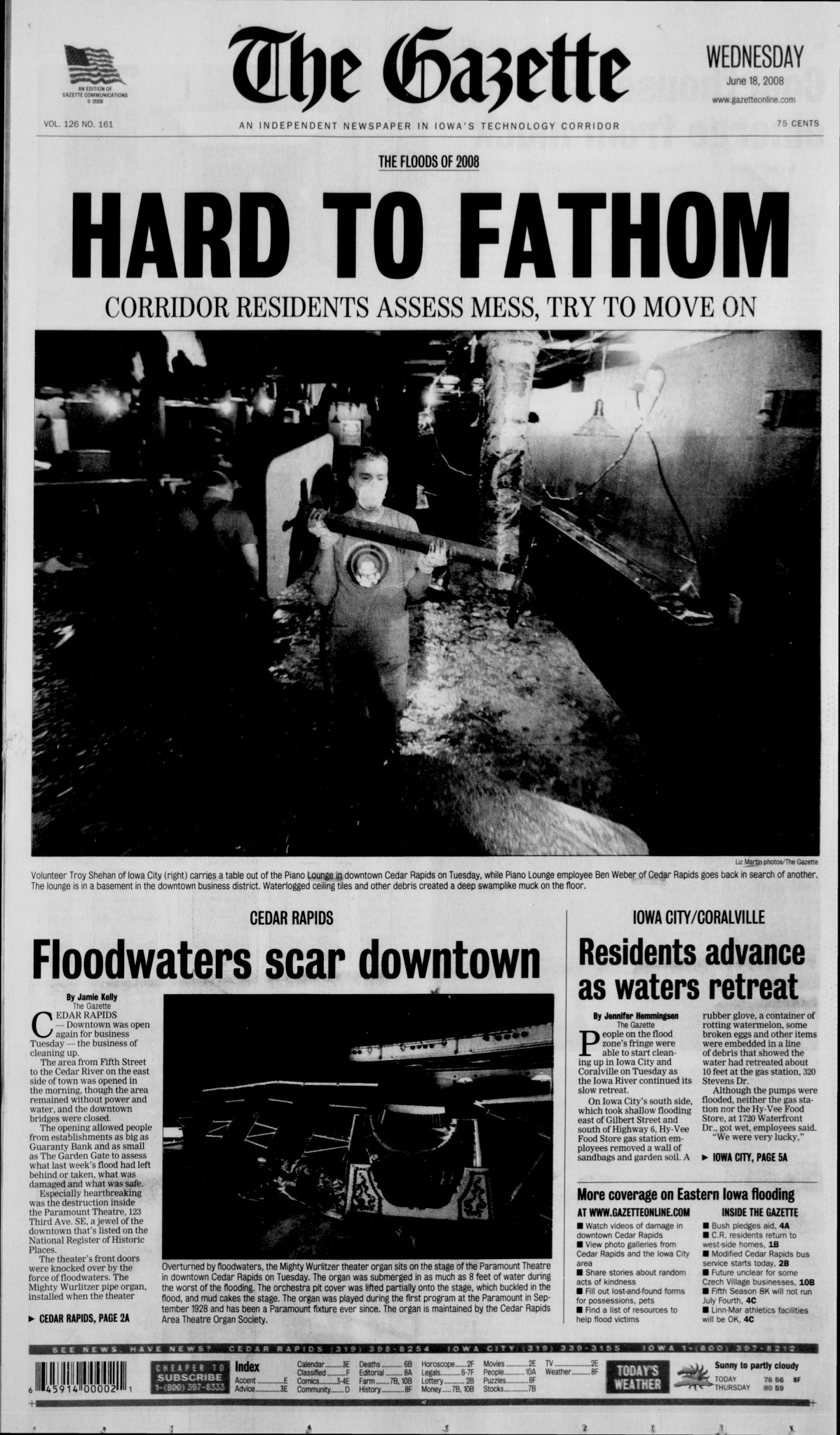 Gazette front page dated June 18, 2000 with headline HARD TO FATHOM and a photo of people walking through floodwater. Below it is a dark photo of the Mighty Wurlitzer knocked over and the headline Floodwaters Scar Downtown.